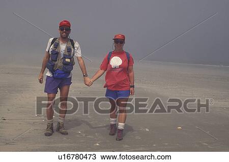 Cumberland Island National Seashore, GA, Golden Isles, barrier island, Georgia, Couple walking on the beach in the fog. View Large Photo Image Stock Image - Cumberland Island National Seashore, GA, Golden Isles, barrier island, Georgia, Couple walking on the beach in the fog.. Fotosearch