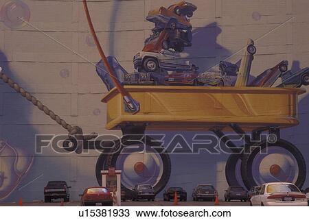 Stock Image -  Dallas, TX, Texas, Wall mural of wagon filled with cars and trucks, downtown. Fotosearch