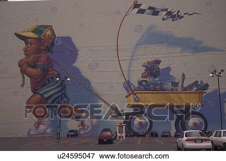 Stock Photo -  Dallas, TX, Texas, Wall mural of young boy toddler pulling a wagon of cars and trucks, downtown. Fotosearch