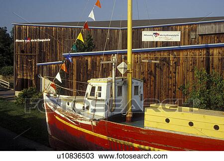 Stock Image -  Gaspe Peninsula, Gaspe, Quebec, Canada, Gulf of St. Lawrence, Red sailing vessel displayed at the Gaspesie Museum (Musee de la Gaspesie) in Gaspe on the Gaspe Peninsula.. Fotosearch