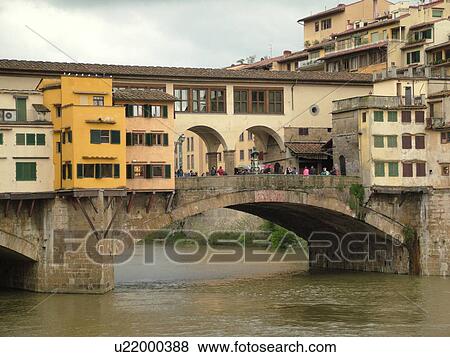 Stock Photo -  Italy, Florence, Tuscany, Firenza, Toscana, Europe, Ponte Vecchio, a bridge lined with shops, crosses the River Arno in the city of Florence.. Fotosearch