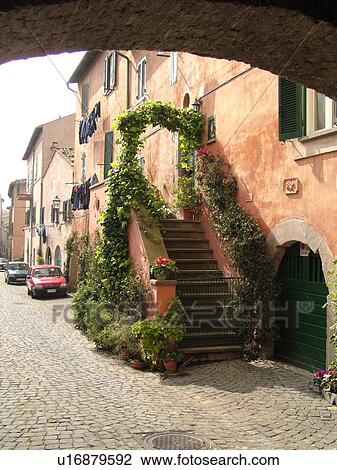 Stock Image -  Italy, Lazio, Tuscania, Europe, Stairway covered with ivy and flowers in the village of Tuscania.. Fotosearch