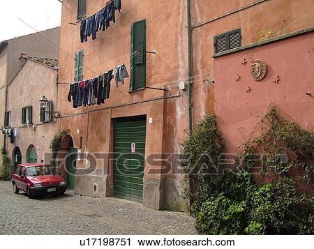 Stock Image -  Italy, Lazio, Tuscania, Europe, Laundry hanging along the side of a wall in the village of Tuscania.. Fotosearch