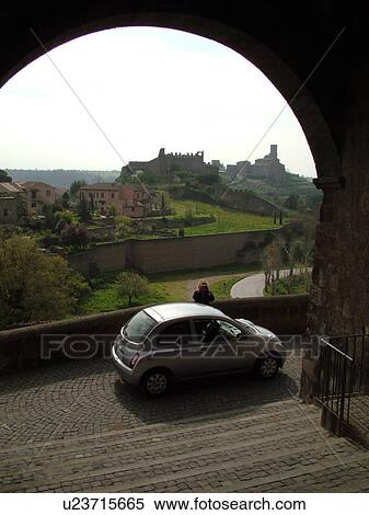 Stock Photography -  Italy, Lazio, Tuscania, Europe, View of the village of Tuscania through an archway.. Fotosearch