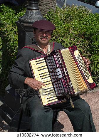 Italy, Rapallo, Riviera di Levante, Liguria, Ligurian Riviera, Europe, Accordion player entertains along the waterfront of the resort town of Rapallo along the Ligurian Sea. View Large Photo Image Picture - Italy, Rapallo, Riviera di Levante, Liguria, Ligurian Riviera, Europe, Accordion player entertains along the waterfront of the resort town of Rapallo along the Ligurian Sea.. Fotosearch