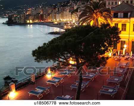 Stock Photo -  Liguria, Italy, Camogli, Riviera di Levante, Ligurian Riviera, Europe, Scenic view of the waterfront of the resort town of Camogli in the evening from the terrace of a resort hotel along the Ligurian Sea.. Fotosearch