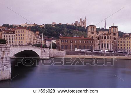 Stock Photo -  Lyon, France, Rhone-Alpes, Europe, Cathedral Saint Jean (below) and Basilique Notre Dame de Fourviere (above) along the Saone River in Lyon.. Fotosearch