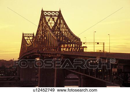 Stock Photo -  Montreal, Canada, Quebec, Pont Jacques Cartier (Jacques Cartier Bridge) at sunset crossing the St. Lawrence River (Fleuve Saint-Laurent) in Montreal.. Fotosearch