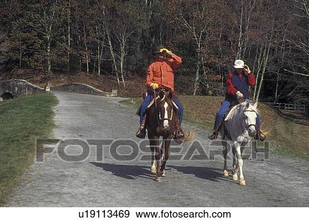 Stock Photo -  NC, North Carolina, Moses Cone Memorial Park, people horseback riding, fall, trail. Fotosearch