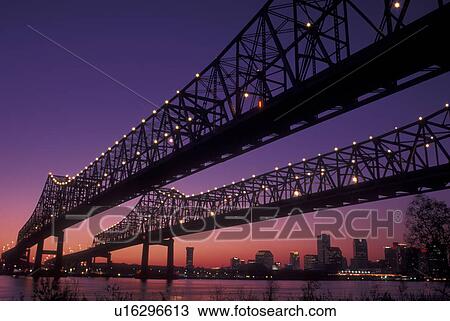 Stock Image -  New Orleans, LA, Louisiana, Mississippi River, Greater New Orleans Bridge, evening, skyline. Fotosearch