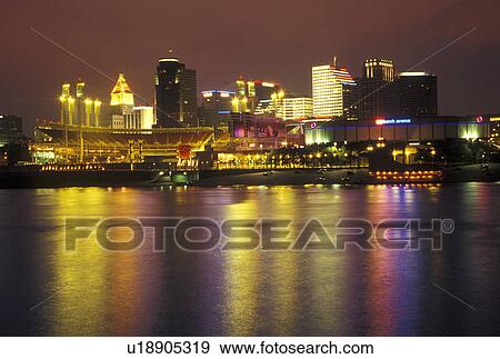 Stock Photo -  OH, Ohio, Cincinnati, Downtown skyline along the Ohio River, evening. Fotosearch