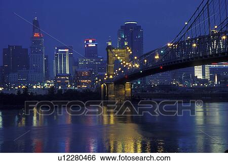 Stock Photograph -  OH, Ohio, Cincinnati, Downtown skyline along the Ohio River, evening. Fotosearch