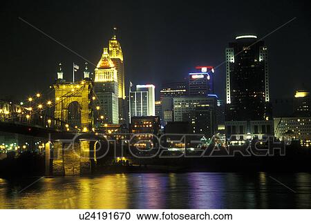 Stock Image -  Ohio, Cincinnati, OH, Downtown skyline along the Ohio River, evening. Fotosearch