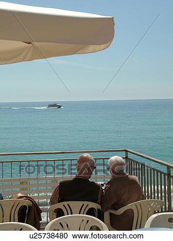 Stock Image -  outdoor cafT, Italy, Liguria, Camogli, Riviera di Levante, Ligurian Riviera, Europe, Outdoor cafT along the waterfront of the resort town of Camogli looking out over the Ligurian Sea.. Fotosearch