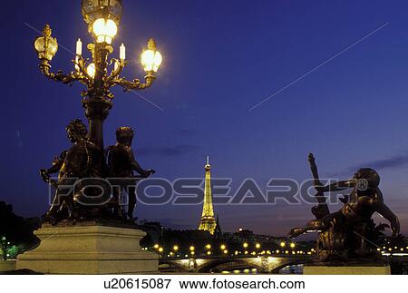 Stock Photo -  Paris, Ile de France, France, Europe, Ponte de la Concorde and Eiffel Tower along the Seine River in the city of Paris in the evening.. Fotosearch