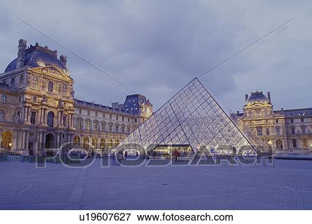 Stock Photo -  Paris, Ile de France, The Louvre, France, Europe, The glass pyramid marks the entrance to the Musee du Louvre (Louvre Museum) in Paris in the evening. . Fotosearch