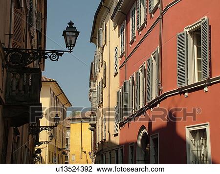 Stock Image -  Parma, Emilia-Romagna, Italy, Europe, Buildings along a narrow street in the city of Parma.. Fotosearch