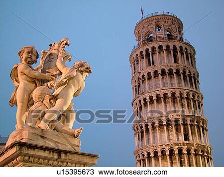 Stock Image -  Pisa, Tuscany, Italy, Toscana, Europe, Cupid Statue outside the Leaning Tower of Pisa (Torre Pendente) in Campo dei Miracoli (Field of Miracles) in the evening in the city of Pisa.. Fotosearch