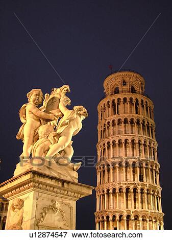 Stock Photo -  Pisa, Tuscany, Italy, Toscana, Europe, Cupid Statue outside the Leaning Tower of Pisa (Torre Pendente) in Campo dei Miracoli (Field of Miracles) in the evening in the city of Pisa.. Fotosearch
