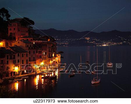 Stock Image -  Portofino, Italy, Riviera di Levante, Ligurian Riviera, Liguria, Europe, Scenic view of the harbor of the resort town of Portofino at night along the Ligurian Sea.. Fotosearch
