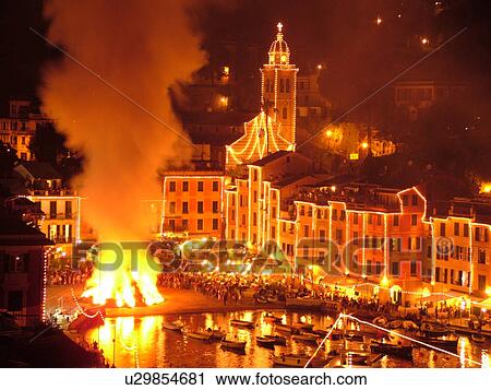 Stock Image -  Portofino, Liguria, Italy, Riviera di Levante, Ligurian Riviera, Europe, A large bonfire burns in the portside square at night celebrating St. George Feast Day (April 23) in the resort town of Portofino along the Ligurian Sea.. Fotosearch
