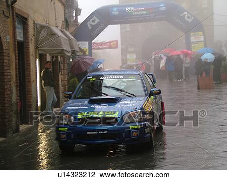 rally car, Italy, Tuscany, Montalcino, Toscana, Europe, Trofeo Rally Coppa Liburna car race through the narrow streets of the medieval town of Montalcino on a rainy day. View Large Photo Image Stock Image - rally car, Italy, Tuscany, Montalcino, Toscana, Europe, Trofeo Rally Coppa Liburna car race through the narrow streets of the medieval town of Montalcino on a rainy day.. Fotosearch