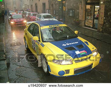 rally car, Tuscany, Italy, Montalcino, Toscana, Europe, The starting line up of the Trofeo Rally Coppa Liburna car race through the narrow streets of the medieval town of Montalcino on a rainy day. View Large Photo Image Stock Photo -  rally car, Tuscany, Italy, Montalcino, Toscana, Europe, The starting line up of the Trofeo Rally Coppa Liburna car race through the narrow streets of the medieval town of Montalcino on a rainy day.. Fotosearch