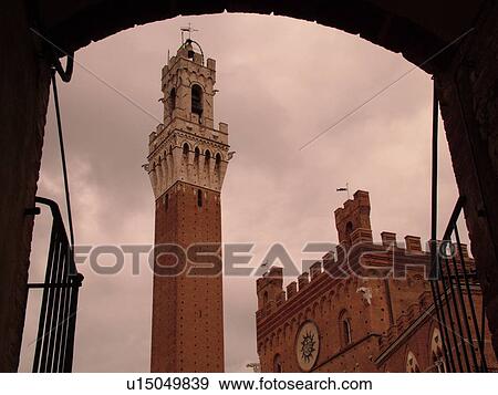 Stock Photo -  Siena, Italy, Tuscany, Toscana, Europe, The Torre del Mangia towers above the Palazzo Pubblico in the city of Siena.. Fotosearch