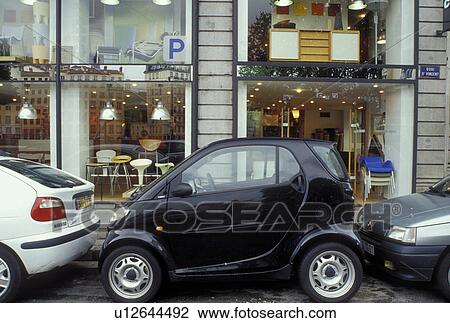 Stock Image -  Swatch Car, Lyon, France, Rhone-Alpes, Europe, Swatch car parallel parked in a small space between two cars in downtown Lyon.. Fotosearch