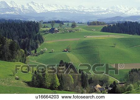 Stock Image -  Switzerland, Emmental, Bern, Affoltern, Europe, Scenic view of the countryside of the Emmental Region and the Alps in the spring in the Canton of Bern. . Fotosearch