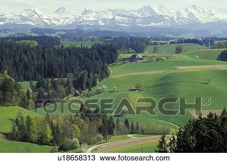 Stock Image -  Switzerland, Emmental, Bern, Affoltern, Europe, Scenic view of the countryside of the Emmental Region and the Alps in the spring in the Canton of Bern. . Fotosearch