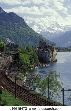 Switzerland, Montreux, Alps, Lake Geneva, Vaud, Europe, Train tracks wind along the lakeshore of Lac Leman with a scenic view of the Alps and the Chateau de Chillon in the spring in the Canton of Vaud. View Large Photo Image Stock Image - Switzerland, Montreux, Alps, Lake Geneva, Vaud, Europe, Train tracks wind along the lakeshore of Lac Leman with a scenic view of the Alps and the Chateau de Chillon in the spring in the Canton of Vaud. . Fotosearch