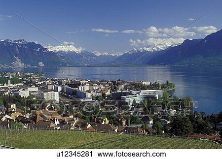Switzerland, Vaud, Vevey, Lake Geneva, Lavaux, Alps, Europe, Scenic view of the city of Vevey and the Alps along the lakeshore of Lac Leman in the spring in the Canton of Vaud. View Large Photo Image Stock Image - Switzerland, Vaud, Vevey, Lake Geneva, Lavaux, Alps, Europe, Scenic view of the city of Vevey and the Alps along the lakeshore of Lac Leman in the spring in the Canton of Vaud.. Fotosearch