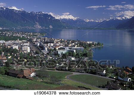 Switzerland, Vevey, Lavaux, Vaud, Lake Geneva, Alps, Europe, Scenic view of the city of Vevey and the Alps along the lakeshore of Lac Leman in the spring in the Canton of Vaud. View Large Photo Image Stock Photo - Switzerland, Vevey, Lavaux, Vaud, Lake Geneva, Alps, Europe, Scenic view of the city of Vevey and the Alps along the lakeshore of Lac Leman in the spring in the Canton of Vaud.. Fotosearch