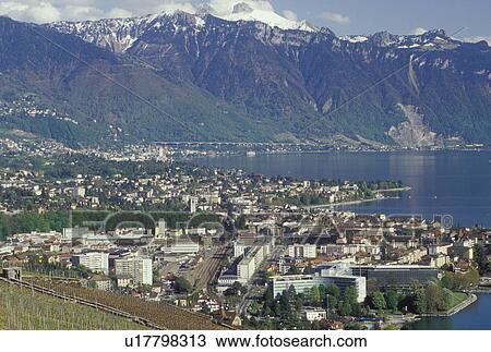 Switzerland, Vevey, Vaud, Lavaux, Lake Geneva, Alps, Europe, Scenic view of the city of Vevey and the Alps along the lakeshore of Lac Leman in the spring in the Canton of Vaud. View Large Photo Image Stock Image - Switzerland, Vevey, Vaud, Lavaux, Lake Geneva, Alps, Europe, Scenic view of the city of Vevey and the Alps along the lakeshore of Lac Leman in the spring in the Canton of Vaud.. Fotosearch
