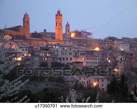Stock Image -  Tuscany, Italy, Montalcino, Toscana, Europe, View of the medieval hilltown of Montalcino in Tuscany in the evening.. Fotosearch