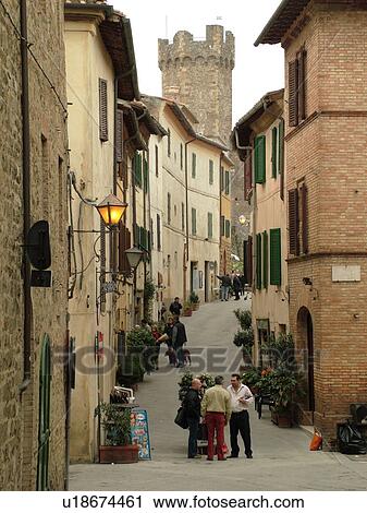Stock Image -  Tuscany, Italy, Montalcino, Toscana, Europe, People talking together on a narrow street in the town of Montalcino. Fotosearch