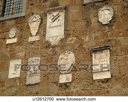 Stock Image -  Tuscany, Italy, Sovana, Toscana, Europe, Old plaques in the wall of an old building in the medieval town of Sovana.. Fotosearch