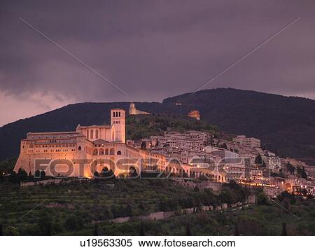 Stock Photography -  Assisi, Italy, Umbria, Europe, Basilica di San Francesco (Basilica of St. Francis of Assisi) and the Sacro Convento illuminated at night on the slopes of Monte Subasio in the medieval hill town of Assisi.. Fotosearch