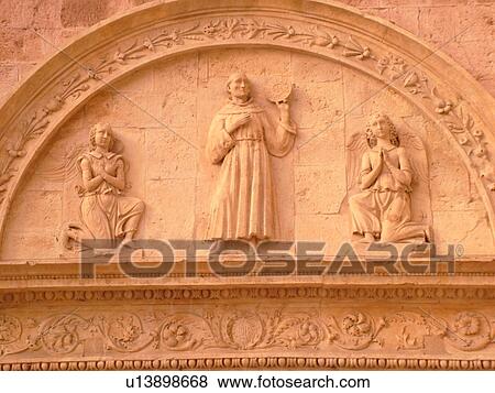 Stock Photo -  Assisi, Umbria, Italy, Europe, Relief carving on the fatade of the Basilica di San Francesco (Basilica of St. Francis of Assisi) and the Sacro Convento in the medieval hill town of Assisi.. Fotosearch