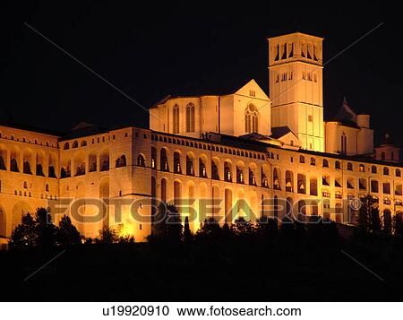 Stock Image -  Assisi, Umbria, Italy, Europe, Basilica di San Francesco (Basilica of St. Francis of Assisi) and the Sacro Convento illuminated at night on the slopes of Monte Subasio in the medieval hill town of Assisi.. Fotosearch