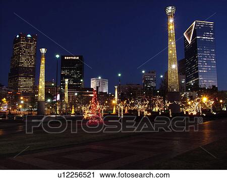 Stock Image -  Atlanta, GA, Georgia, Centennial Park, 1996 Summer Olympics, downtown skyline, evening, Christmas decorations. Fotosearch