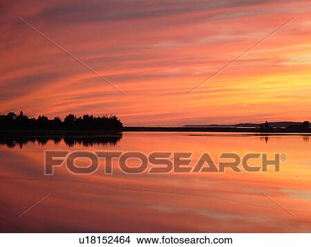 Picture -  Canada, New Brunswick, Maces Bay, Bay of Fundy, Colorful reflection at sunrise on the calm waters of the Bay of Fundy at sunset.. Fotosearch