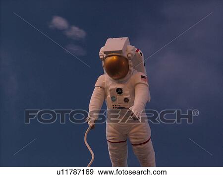 Stock Photo -  Cape Canaveral, Titusville, Merritt Island, FL, Florida, John F. Kennedy Space Center Visitor Complex, Astronaut display against a dark blue sky . Fotosearch