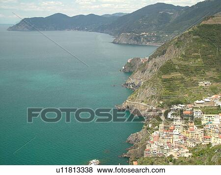 Stock Photo -  Cinque Terre, Liguria, Italy, Riomaggiore, Riviera di Levante, Ligurian Riviera, Europe, Scenic view of Riomaggiore, a Cinque Terre village, along the steep rocky coastline of the Ligurian Sea.. Fotosearch