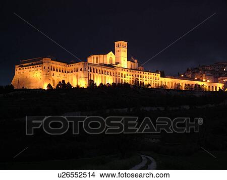 Picture -  Italy, Assisi, Umbria, Europe, Basilica di San Francesco (Basilica of St. Francis of Assisi) and the Sacro Convento illuminated at night on the slopes of Monte Subasio in the medieval hill town of Assisi.. Fotosearch