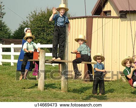 Stock Image -  Lancaster County, PA, Pennsylvania, Amish, school, children playing on playground equipment. Fotosearch