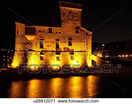 Stock Image -  Liguria, Italy, Rapallo, Riviera di Levante, Ligurian Riviera, Europe, The Castle at night on the Gulf of Tigullio (Gulfo di Tigullo) in the resort town of Rapallo along the Ligurian Sea on the Ligurian Riviera.. Fotosearch