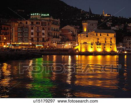 Stock Photo -  Liguria, Italy, Rapallo, Riviera di Levante, Ligurian Riviera, Europe, Hotel Italia and the Castle at night on the Gulf of Tigullio (Gulfo di Tigullo) in the resort town of Rapallo along the Ligurian Sea on the Ligurian Riviera.. Fotosearch