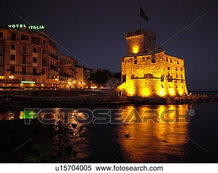 Liguria, Italy, Rapallo, Riviera di Levante, Ligurian Riviera, Europe, Hotel Italia and the Castle at night on the Gulf of Tigullio (Gulfo di Tigullo) in the resort town of Rapallo along the Ligurian Sea on the Ligurian Riviera. View Large Photo Image Stock Photography - Liguria, Italy, Rapallo, Riviera di Levante, Ligurian Riviera, Europe, Hotel Italia and the Castle at night on the Gulf of Tigullio (Gulfo di Tigullo) in the resort town of Rapallo along the Ligurian Sea on the Ligurian Riviera.. Fotosearch